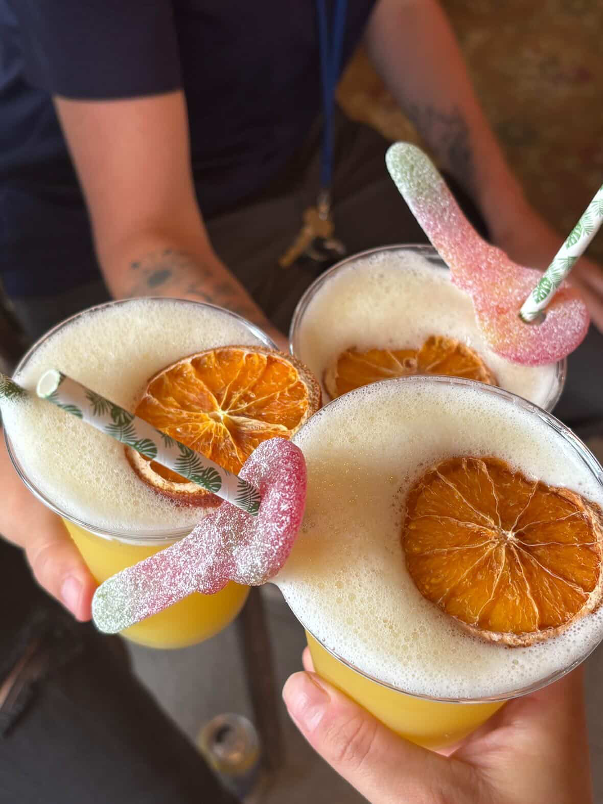 Bright cocktails with dried citrus and playful candy garnishes