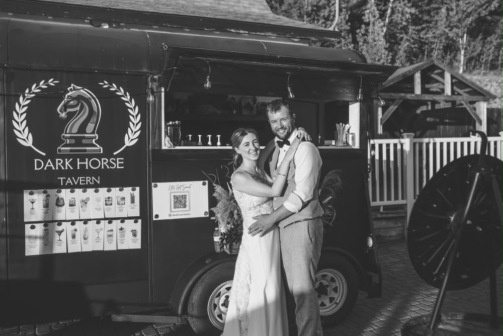 Newlyweds celebrating together in front of the Dark Horse Tavern trailer